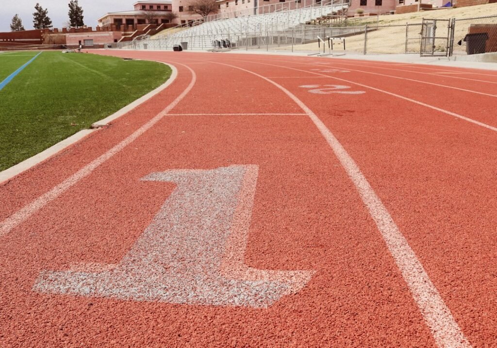 A red running track with a white arrow painted on it
