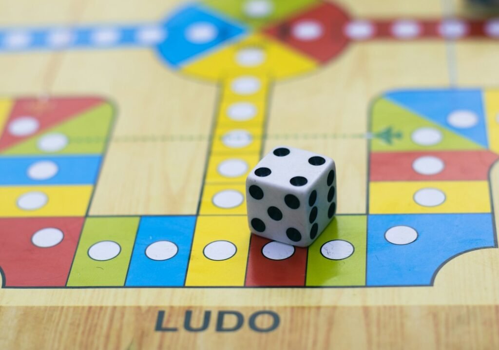 A die on a colourful Ludo board